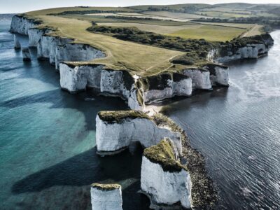Breathtaking aerial view of England's scenic Old Harry Rocks on a sunny day.
