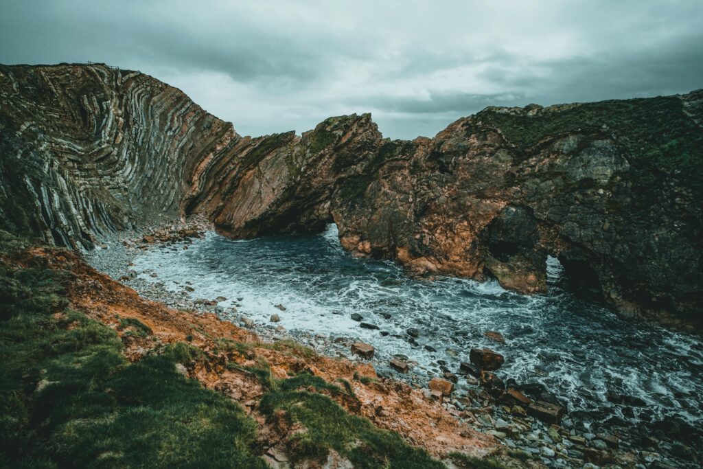 Dramatic coastal cliffs and rugged rock formations at Lulworth Cove, United Kingdom.